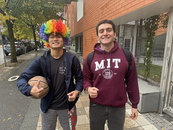 Students standing side by side one wearing a clown wig and the other wearing an MIT sweatshirt