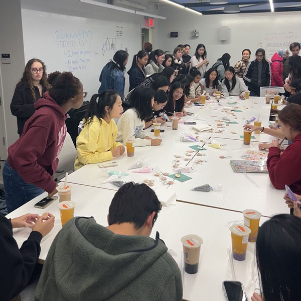 Students gathered around a table working on crafts