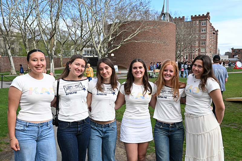 Five students wearing white shirts standing in front of the MIT Chapel.
