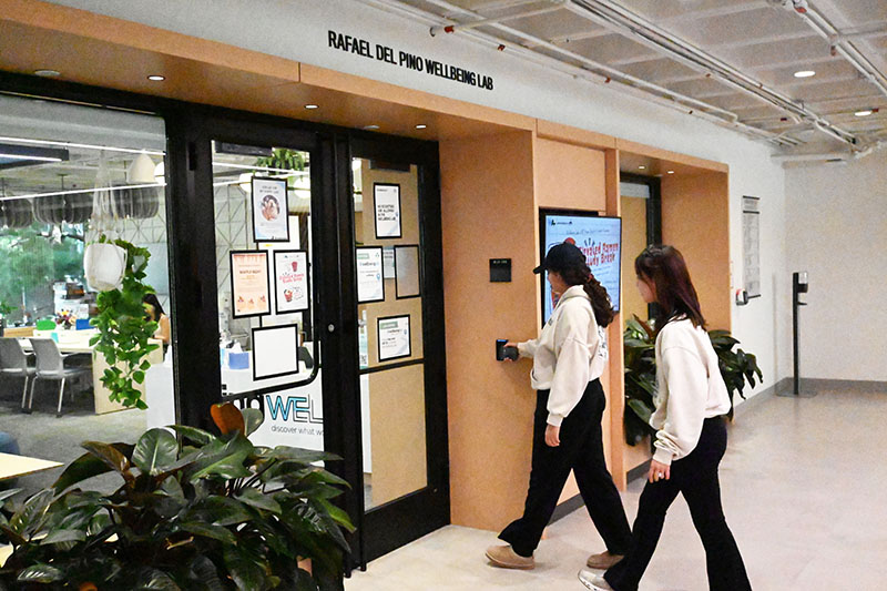 Two students walking through the front door of the Wellbeing Lab